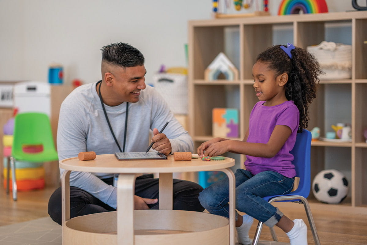 male Occupational Therapist working with young girl during therapy session